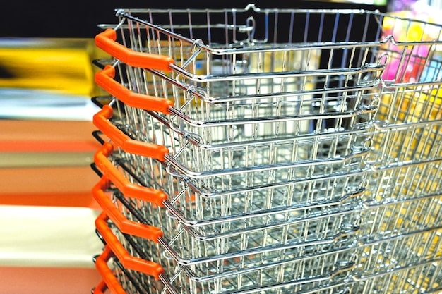 A shopping cart filled with groceries, with price tags that have been marked up to reflect a 3.5% increase in prices due to inflation. The setting is a typical US supermarket.