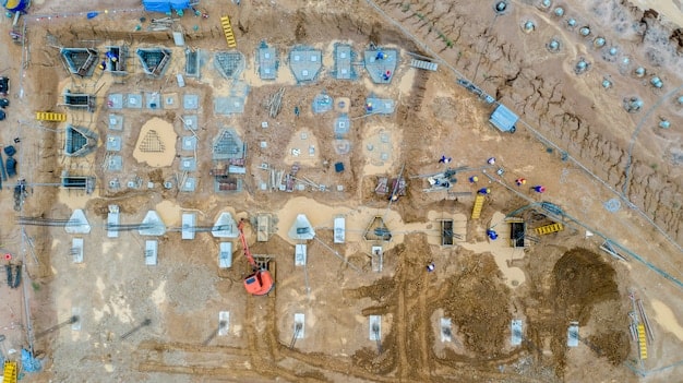 An aerial view of a construction site for a new bridge, showing heavy machinery and workers, emphasizing job creation and economic activity.