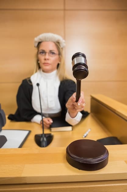 A close-up shot of a gavel striking a sound block in a courtroom setting, symbolizing the decision-making process of the Federal Reserve regarding interest rates. The background is slightly blurred to focus on the gavel and sound block.