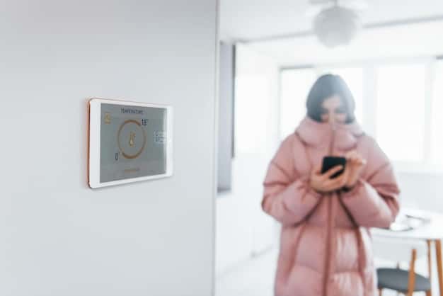 A close-up of a smart thermostat mounted on a wall, displaying a user-friendly interface and showing current temperature and energy-saving settings.