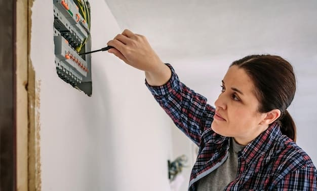 A person installing a smart energy monitor on a home's electrical panel, with visible wires and tools, showcasing the installation process.