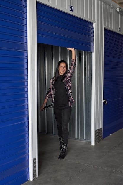 A technician performing maintenance on a garage door, lubricating the rollers and inspecting the springs. The background shows a well-maintained garage interior with various tools and equipment.